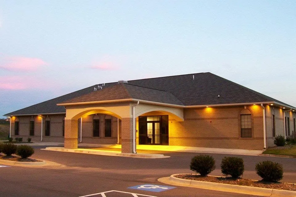 Chenal Valley Baptist Church at dusk, its entrance lit against an evening sky
